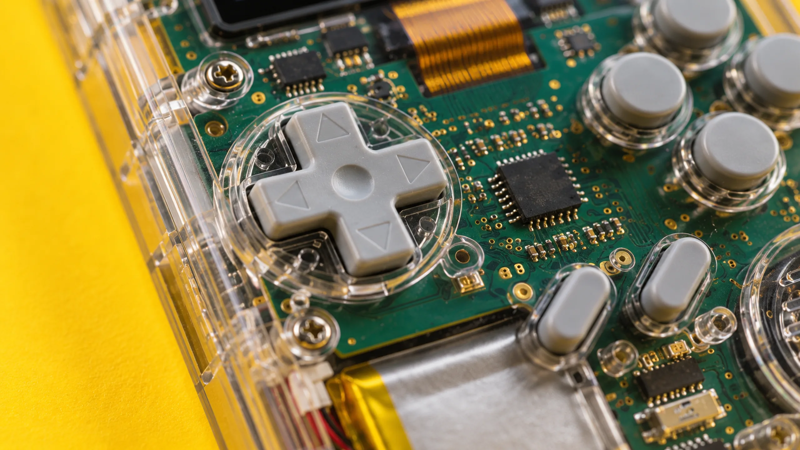 Buttern branded detail artwork: A clear-plastic handheld console on butter yellow